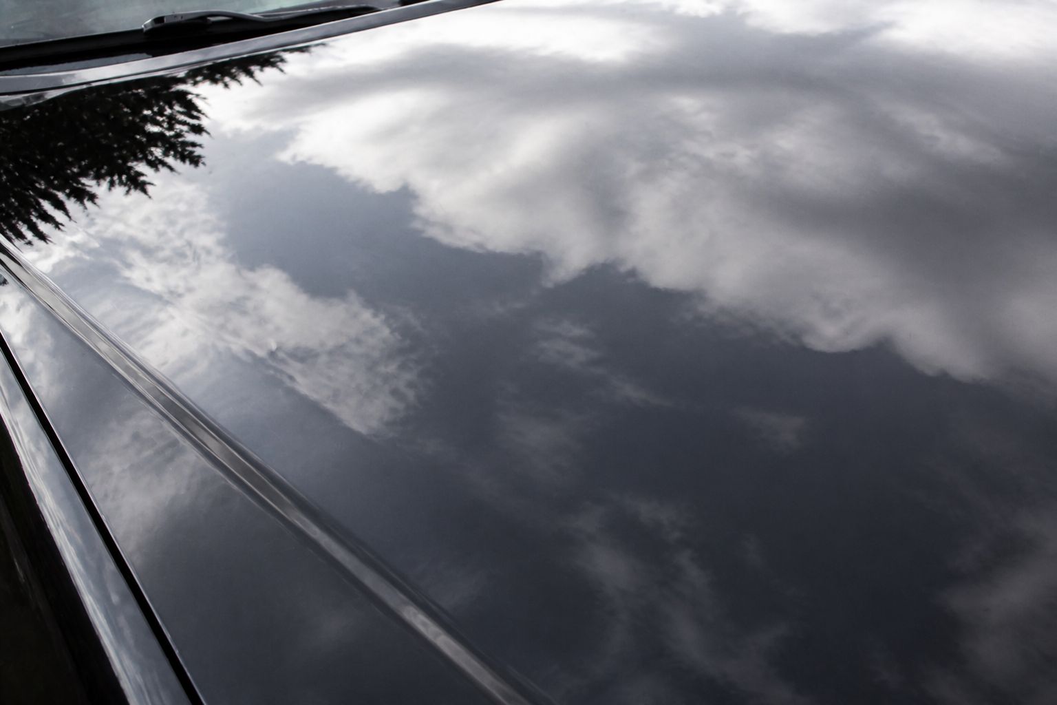 The same hood after paint correction and ceramic coating, mirror-gloss finish