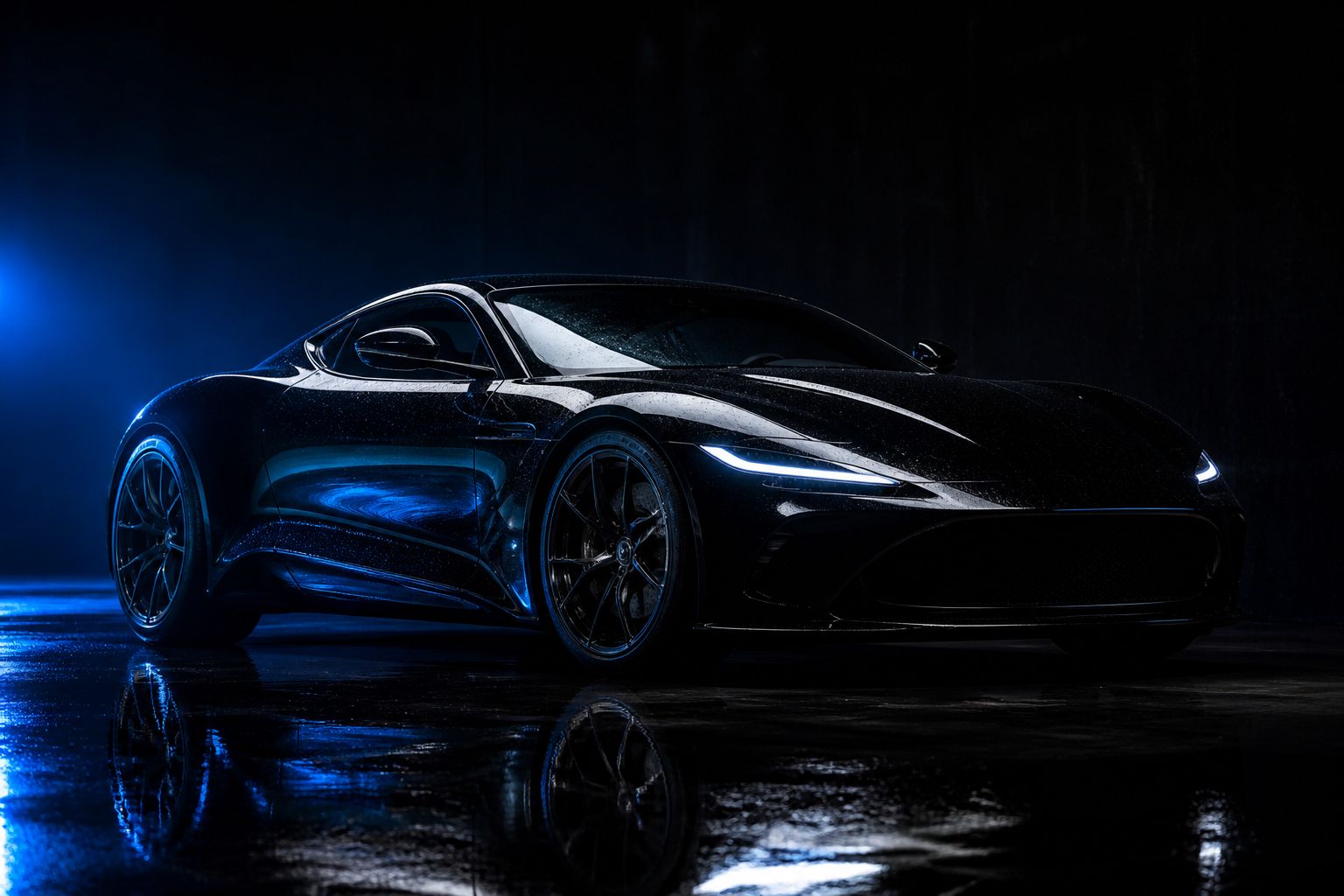 A glossy black sports car in a dark studio with dramatic raking light across the ceramic-coated paint
